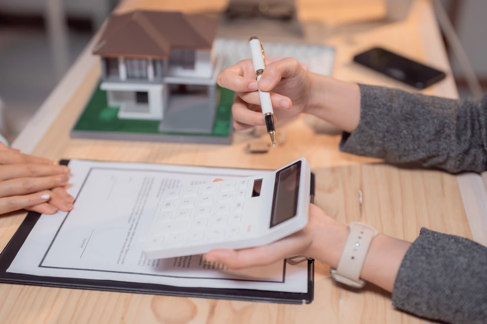 Une main pointe vers une ic&ocirc;ne de c&oelig;ur avec battement cardiaque parmi sept cercles flottants repr&eacute;sentant diff&eacute;rents services d'assurance sur fond de ciel bleu nuageux